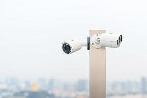 câmera de cctv moderna contra o fundo da cidade e do céu. conceito de vigilância, gravação de vídeo e monitoramento foto