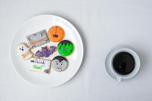 xícara de café quente com biscoitos engraçados de halloween. feliz dia das bruxas, truque ou ameaça, olá outubro, outono outono, tradicional, festa e conceito de feriado foto