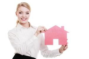 Mulher de negócios agente imobiliária segurando uma casa de papel vermelha foto