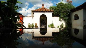 arquitetura colonial, arcos cercados por vegetação, jogo de luzes e sombras no interior do espaço, materiais naturais foto