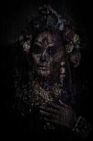 closeup retrato de uma mulher com uma maquiagem de caveira de açúcar vestida com coroa de flores sobre fundo de textura de madeira. foto