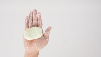 gesto de lavar as mãos com sabão em barra e bolha de espuma no fundo branco. foto
