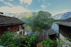 famosa cidade velha hallstatt e lago azul profundo alpino com navio turístico, áustria. foto