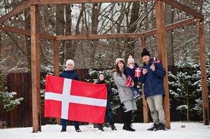 família com bandeiras da Dinamarca ao ar livre no inverno. viajar para países escandinavos. o povo dinamarquês mais feliz. foto