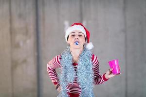 mulher de negócios jovem usando um chapéu vermelho e soprando apito de festa foto