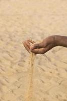 homem segurando um pouco de areia na mão: seca e desertificação