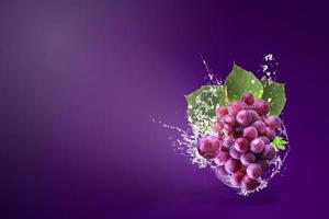 água espirrando em uvas vermelhas frescas foto
