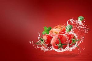água espirrando em tomates vermelhos frescos foto