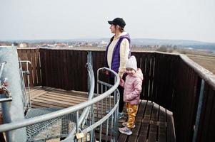 mãe com filha na torre de observação de madeira. foto