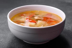 closeup de uma tigela de macarrão de frango e sopa de legumes em uma mesa de concreto foto