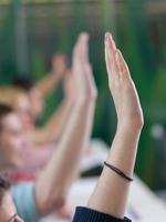 grupo de alunos levanta as mãos na aula foto