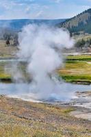 gêiser em erupção na bacia de gêiser no parque nacional de yellowstone foto