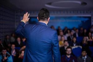 empresário de sucesso dando apresentações na sala de conferências foto