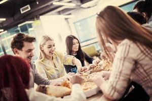 equipe de negócios multiétnica comendo pizza foto