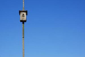 casa de pássaro de madeira velha e fundo de céu azul