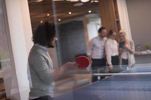 equipe de negócios de inicialização jogando tênis de pingue-pongue foto