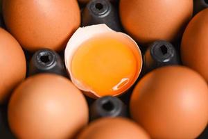 ovos de galinha de produtos agrícolas naturais na caixa conceito de alimentação saudável - gema de ovo quebrada fresca foto