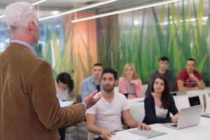 professor com um grupo de alunos em sala de aula foto