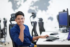 homem de negócios indiano casual trabalhando no computador desktop foto