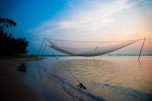 cena calma de rede de pesca contra o pôr do sol roxo.