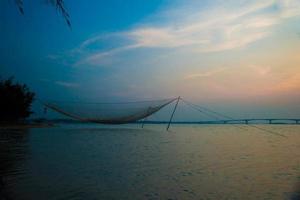 cena calma de rede de pesca contra o pôr do sol roxo.