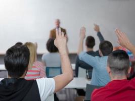 grupo de alunos levanta as mãos na aula foto