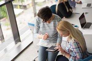 bonitas mulheres de negócios usando tablet em prédio de escritórios durante a conferência foto