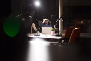 empresário sentado com as pernas na mesa no escritório foto