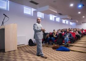 empresário de sucesso dando apresentações na sala de conferências foto