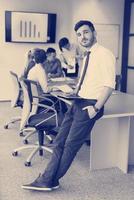 homem de negócios jovem com tablet na sala de reuniões do escritório foto