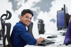 homem de negócios indiano casual trabalhando no computador desktop foto