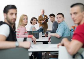 professor com um grupo de alunos em sala de aula foto