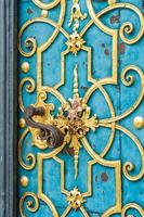porta azul decorada com adorno dourado e maçaneta
