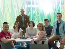 retrato de professor em sala de aula com grupo de alunos em segundo plano foto