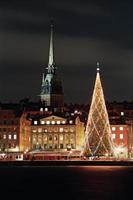 visão noturna da cidade velha de stockholms com árvore de natal foto