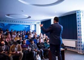 empresário de sucesso dando apresentações na sala de conferências foto