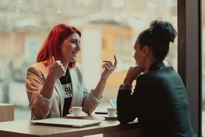 duas mulheres de negócios jovem sentado à mesa em cafe.girl usando laptop, smartphone, blogs. trabalho em equipe, reunião de negócios. freelancers trabalhando... foto