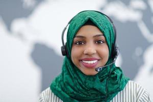 mulher muçulmana africana com fone de ouvido de telefone ajudando e apoiando online foto