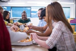 equipe de negócios multiétnica comendo pizza foto