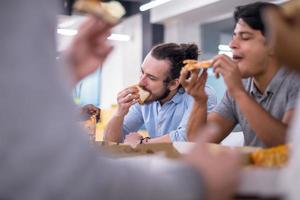 equipe de negócios multiétnica comendo pizza foto