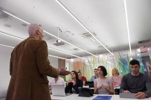 professor com um grupo de alunos em sala de aula foto