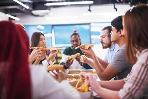 equipe de negócios multiétnica comendo pizza foto