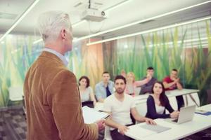 professor com um grupo de alunos em sala de aula foto