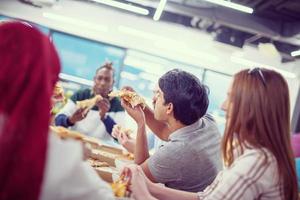 equipe de negócios multiétnica comendo pizza foto