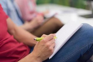 estudante do sexo masculino tomando notas em sala de aula foto