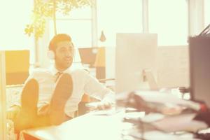 relaxado jovem empresário primeiro no local de trabalho no início da manhã foto