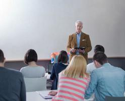 professor com um grupo de alunos em sala de aula foto