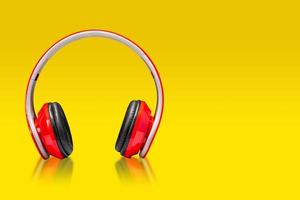 alto-falante de fone de ouvido vermelho, fones de ouvido de alto-falante portátil em fundo amarelo foto