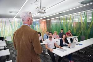 professor com um grupo de alunos em sala de aula foto