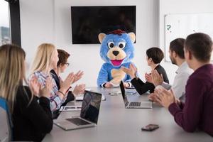 chefe vestido de urso se divertindo com empresários no escritório da moda foto